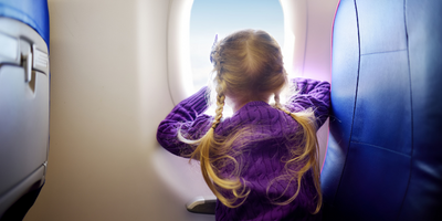 Little girl looking out airplane window
